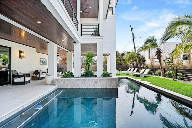 view of swimming pool featuring ceiling fan and a patio area