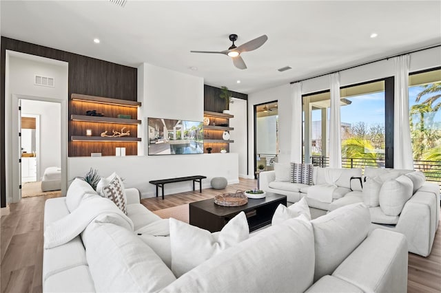 living room with ceiling fan and light hardwood / wood-style flooring