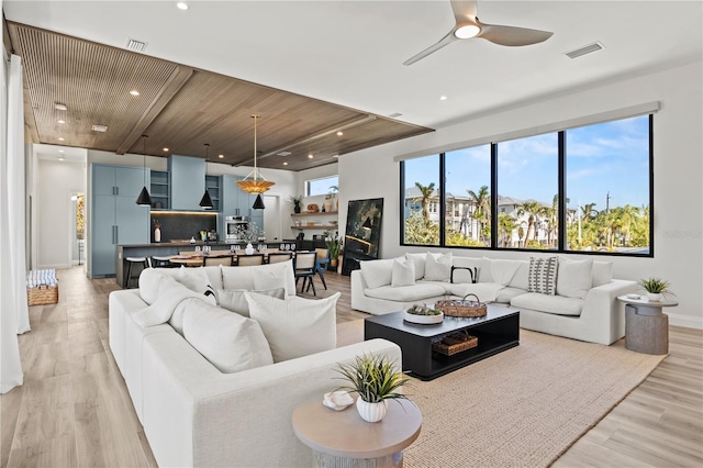 living room with ceiling fan, light wood-type flooring, and wood ceiling