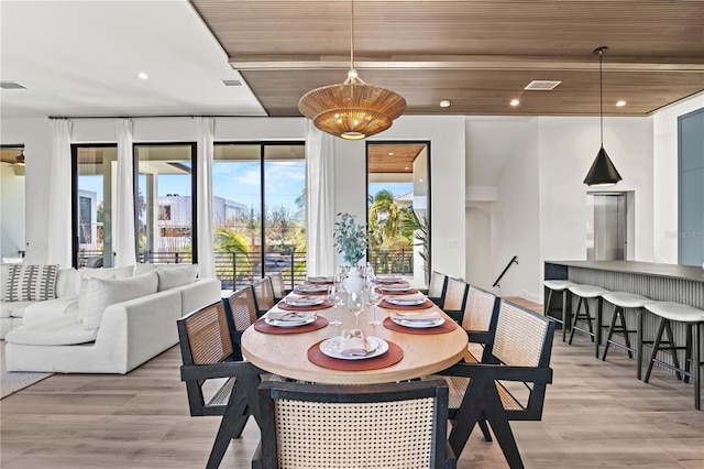 dining room with light wood-type flooring and wooden ceiling