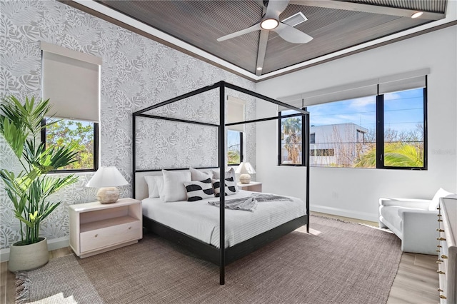 bedroom with multiple windows, light hardwood / wood-style floors, ceiling fan, and crown molding