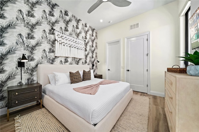 bedroom with light hardwood / wood-style floors and ceiling fan