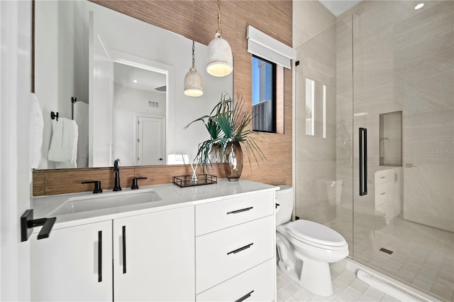 bathroom featuring toilet, vanity, tile patterned floors, and a shower with shower door