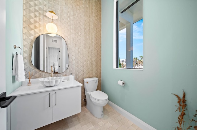 bathroom featuring vanity, toilet, and a wealth of natural light