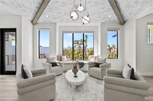 living room with beamed ceiling, a chandelier, and plenty of natural light