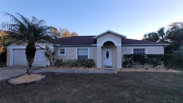 ranch-style home featuring a front lawn and a garage