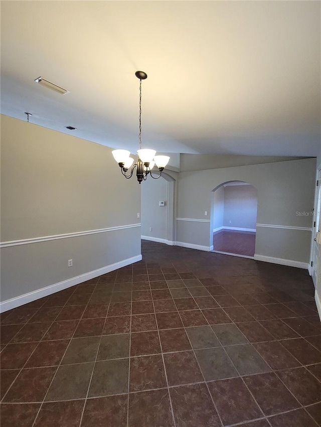 empty room featuring a chandelier and dark tile patterned flooring