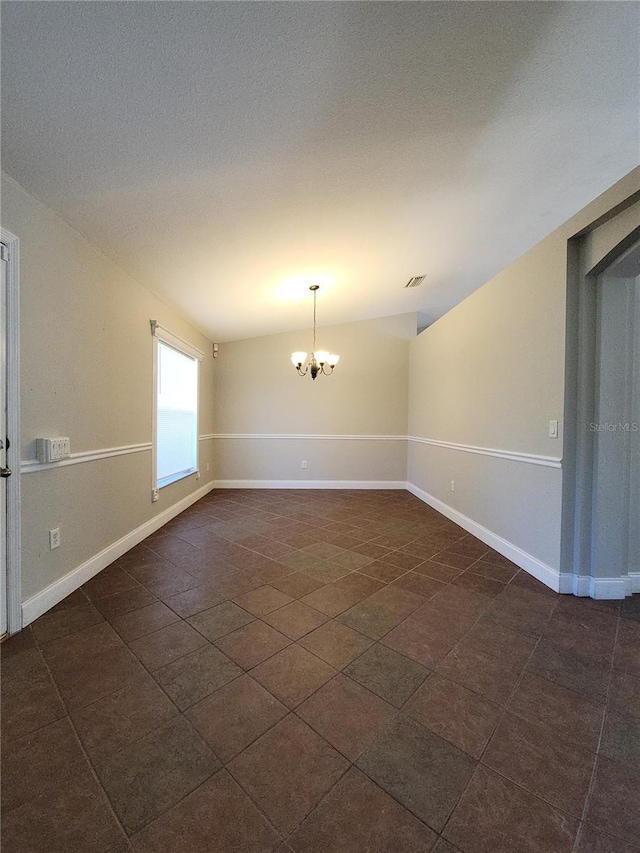 empty room featuring an inviting chandelier