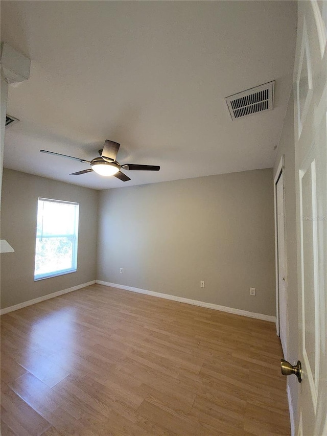 empty room with ceiling fan and light hardwood / wood-style floors