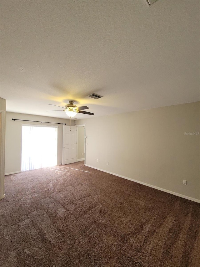 carpeted spare room featuring ceiling fan and a textured ceiling