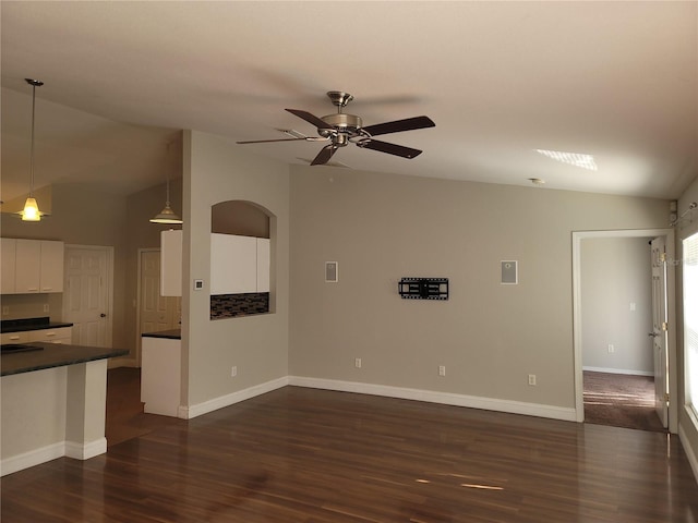 unfurnished living room with ceiling fan, dark wood-type flooring, and lofted ceiling