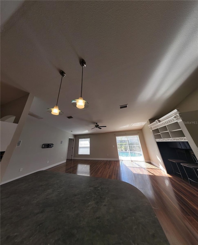 unfurnished living room featuring ceiling fan and wood-type flooring