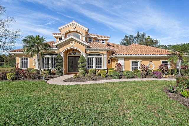 mediterranean / spanish-style home with a front yard and french doors