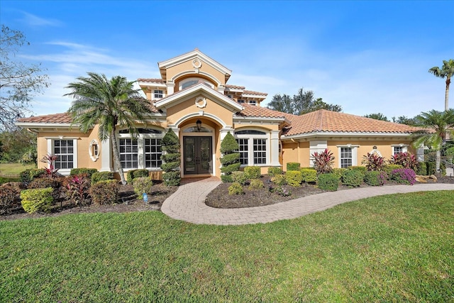 mediterranean / spanish house featuring french doors and a front lawn