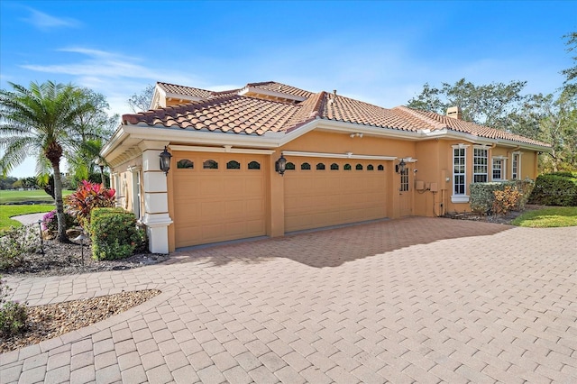 mediterranean / spanish home with a garage