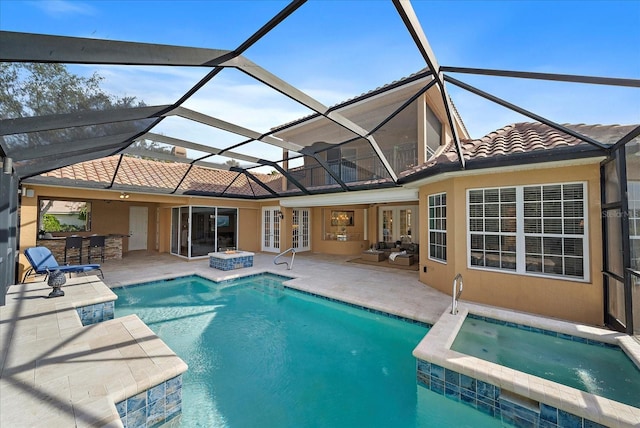 view of pool with an in ground hot tub, french doors, a bar, glass enclosure, and a patio