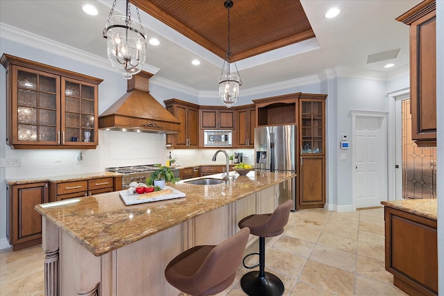 kitchen featuring sink, an inviting chandelier, a raised ceiling, custom exhaust hood, and appliances with stainless steel finishes