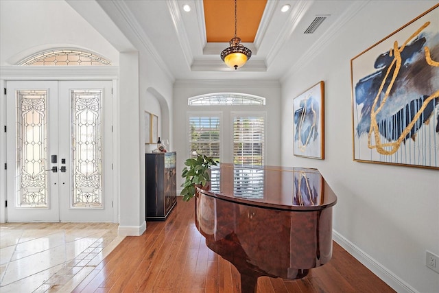 entryway featuring french doors, a raised ceiling, crown molding, and wood-type flooring