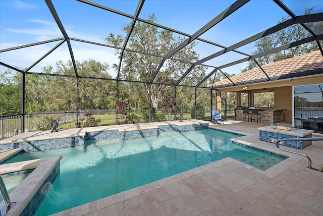 view of swimming pool featuring a lanai, pool water feature, exterior bar, an in ground hot tub, and a patio