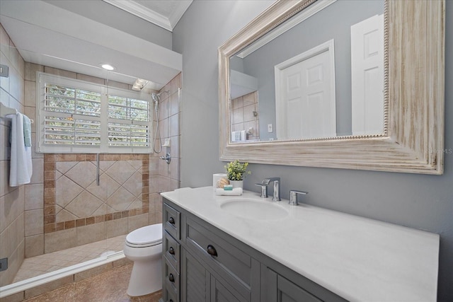 bathroom featuring vanity, crown molding, tile patterned flooring, toilet, and tiled shower