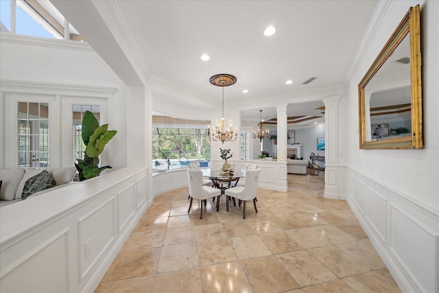 dining room featuring ornate columns, crown molding, french doors, and an inviting chandelier