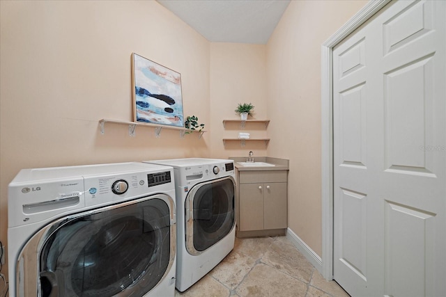 laundry area featuring cabinets, sink, and washing machine and clothes dryer