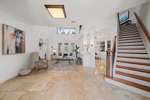 entrance foyer with french doors, an inviting chandelier, and ornamental molding