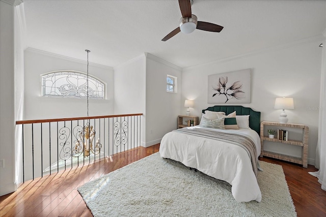 bedroom featuring dark hardwood / wood-style floors, ceiling fan, and crown molding