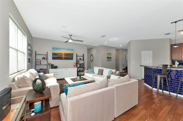 living room featuring ceiling fan and dark hardwood / wood-style flooring