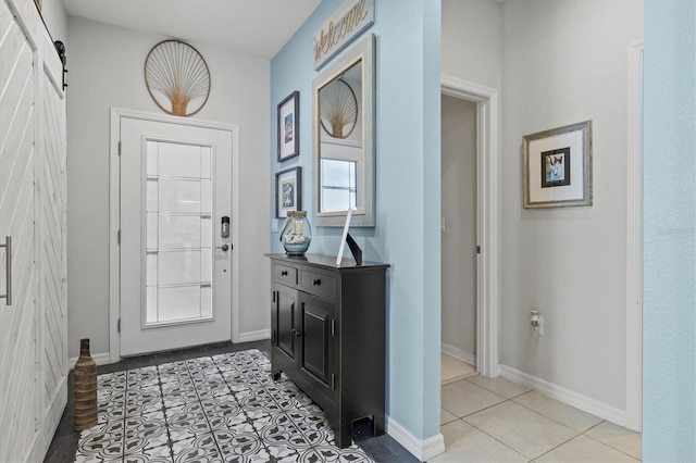 entrance foyer with light tile patterned floors and a barn door