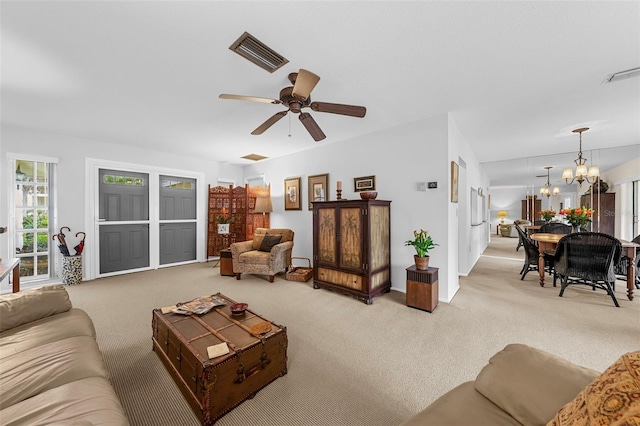 living room with light carpet and ceiling fan with notable chandelier