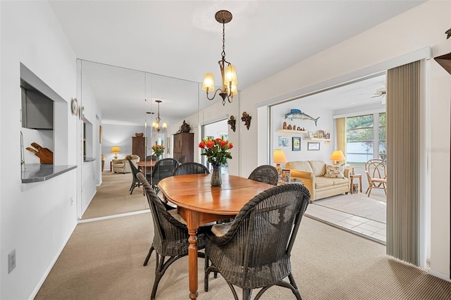 carpeted dining area with ceiling fan with notable chandelier