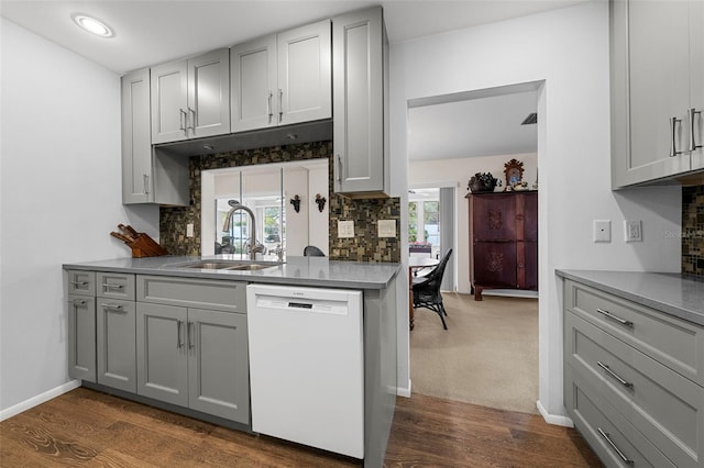 kitchen featuring white dishwasher, gray cabinets, dark wood-type flooring, and sink