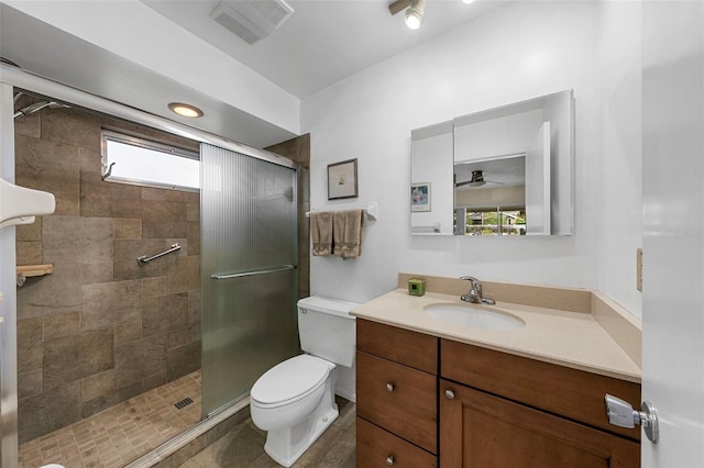 bathroom with a shower with door, vanity, and toilet