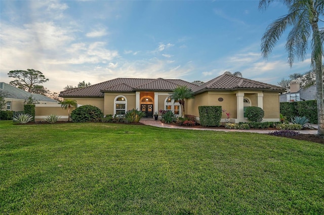 mediterranean / spanish home with a front yard