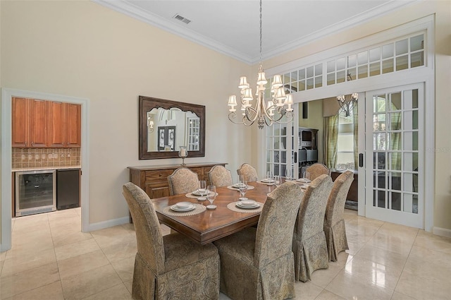 tiled dining area with french doors, crown molding, a notable chandelier, and wine cooler