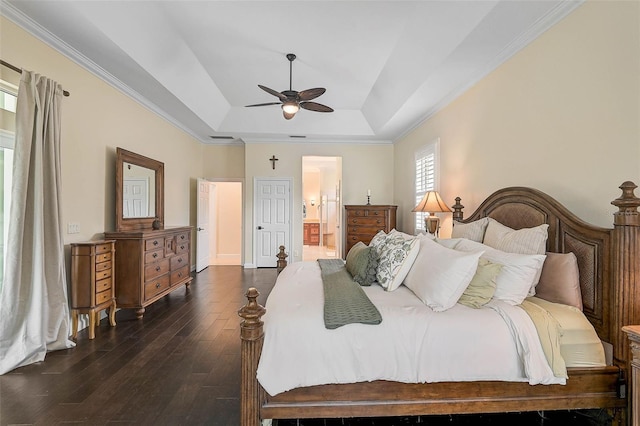 bedroom featuring ensuite bathroom, ceiling fan, a raised ceiling, dark hardwood / wood-style flooring, and crown molding