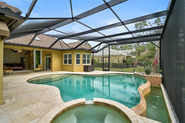 view of swimming pool with an in ground hot tub, a lanai, ceiling fan, and a patio area