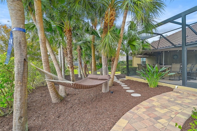 view of yard with a patio area and glass enclosure