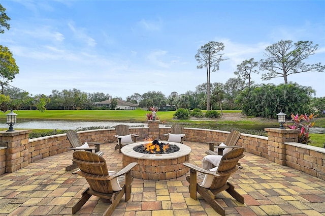 view of patio / terrace featuring a water view and a fire pit