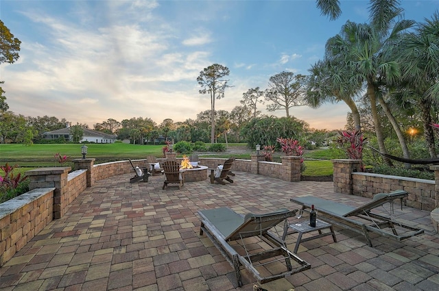 patio terrace at dusk with a yard and a fire pit