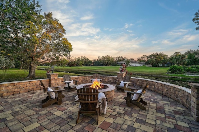 patio terrace at dusk with an outdoor fire pit and a yard