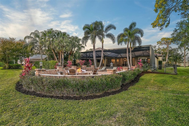 view of yard featuring a lanai, an outdoor fire pit, and a patio