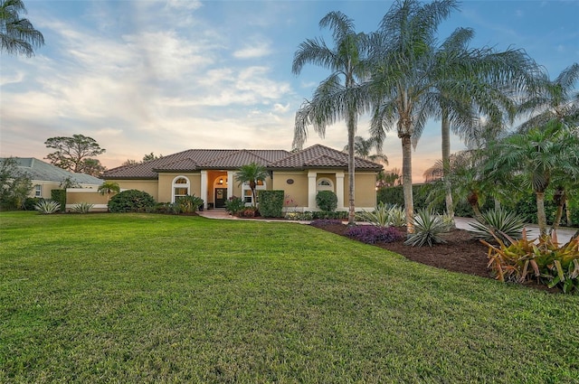 mediterranean / spanish home featuring a yard