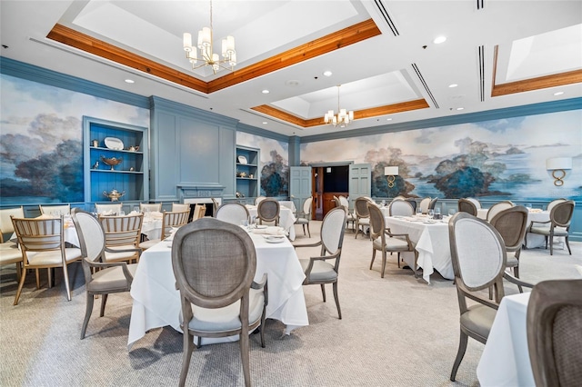 carpeted dining room featuring a chandelier, crown molding, a tray ceiling, and built in shelves