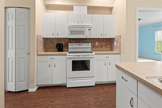 kitchen with tasteful backsplash, white cabinetry, dark hardwood / wood-style floors, and white appliances