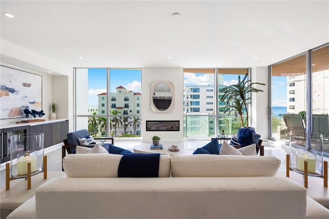 living room featuring plenty of natural light, light wood-type flooring, and a wall of windows