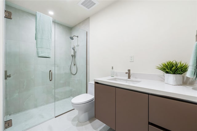 bathroom with vanity, toilet, a shower with door, and tile patterned flooring