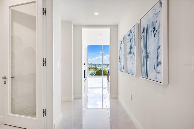 corridor with light tile patterned floors and floor to ceiling windows