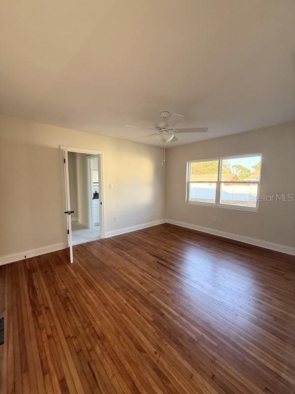 unfurnished room featuring ceiling fan and dark hardwood / wood-style flooring